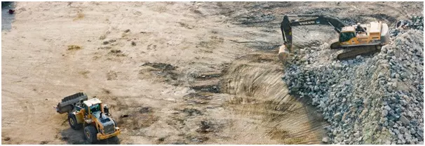 Quarry with digger and dozer, illustrating example of pricing sand