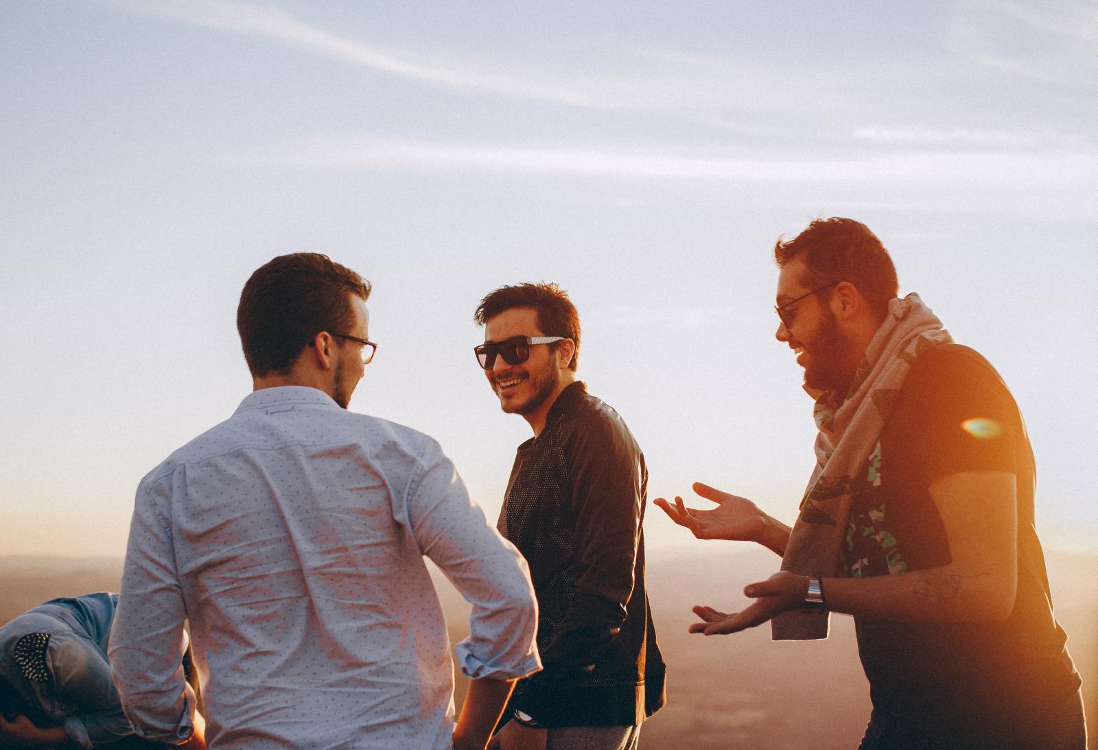 Group of young men laughing and joking on a beach