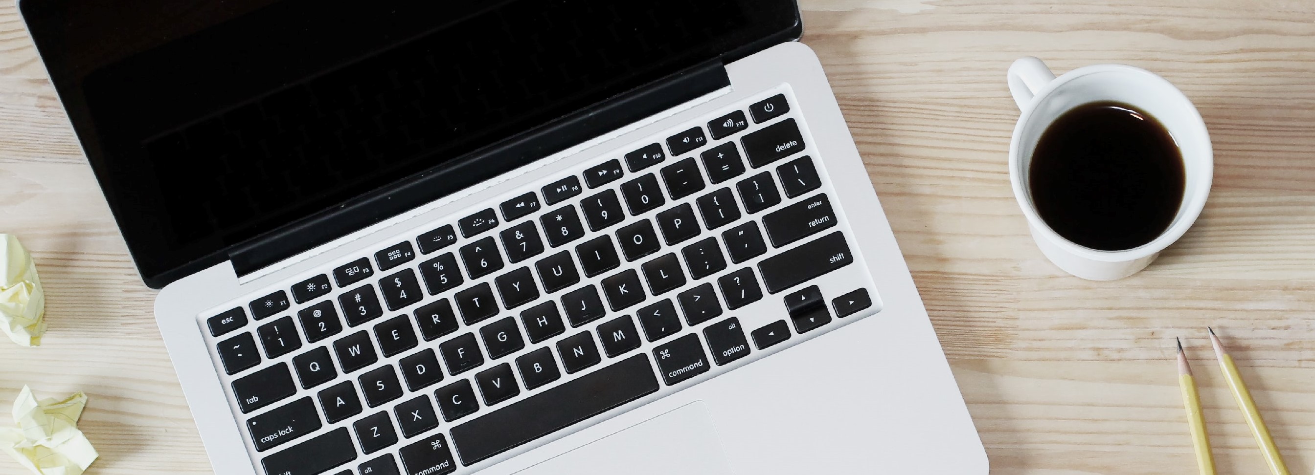 Open Macbook with coffee sitting on a desk