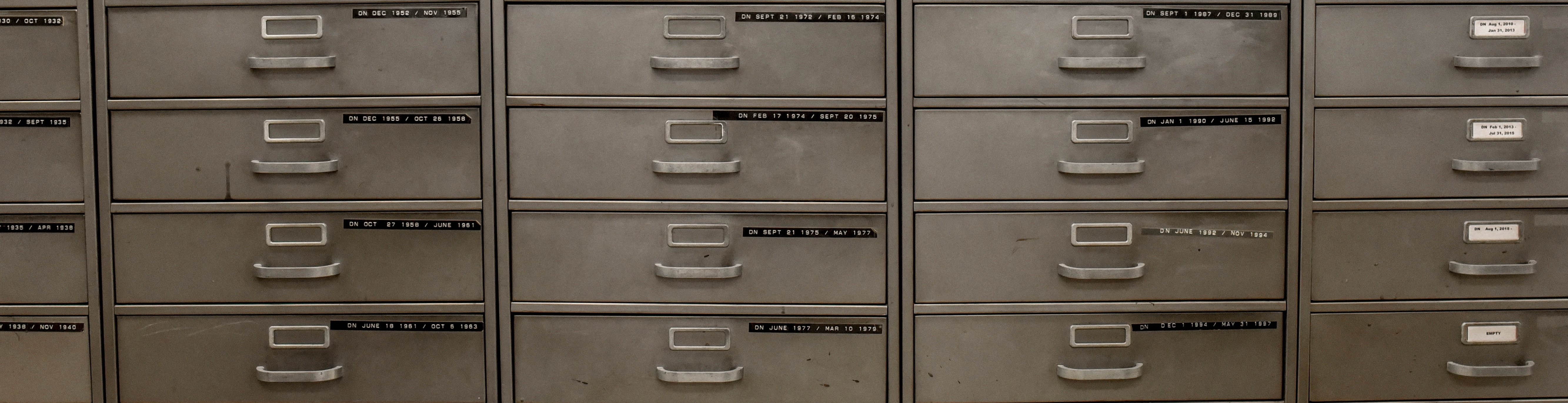 large row of filing cabinets with many small drawers